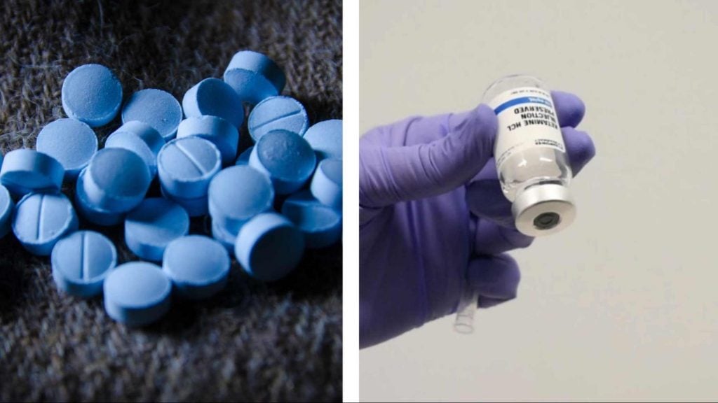 A close-up view of blue tablets scattered on a textured surface, resembling medication.